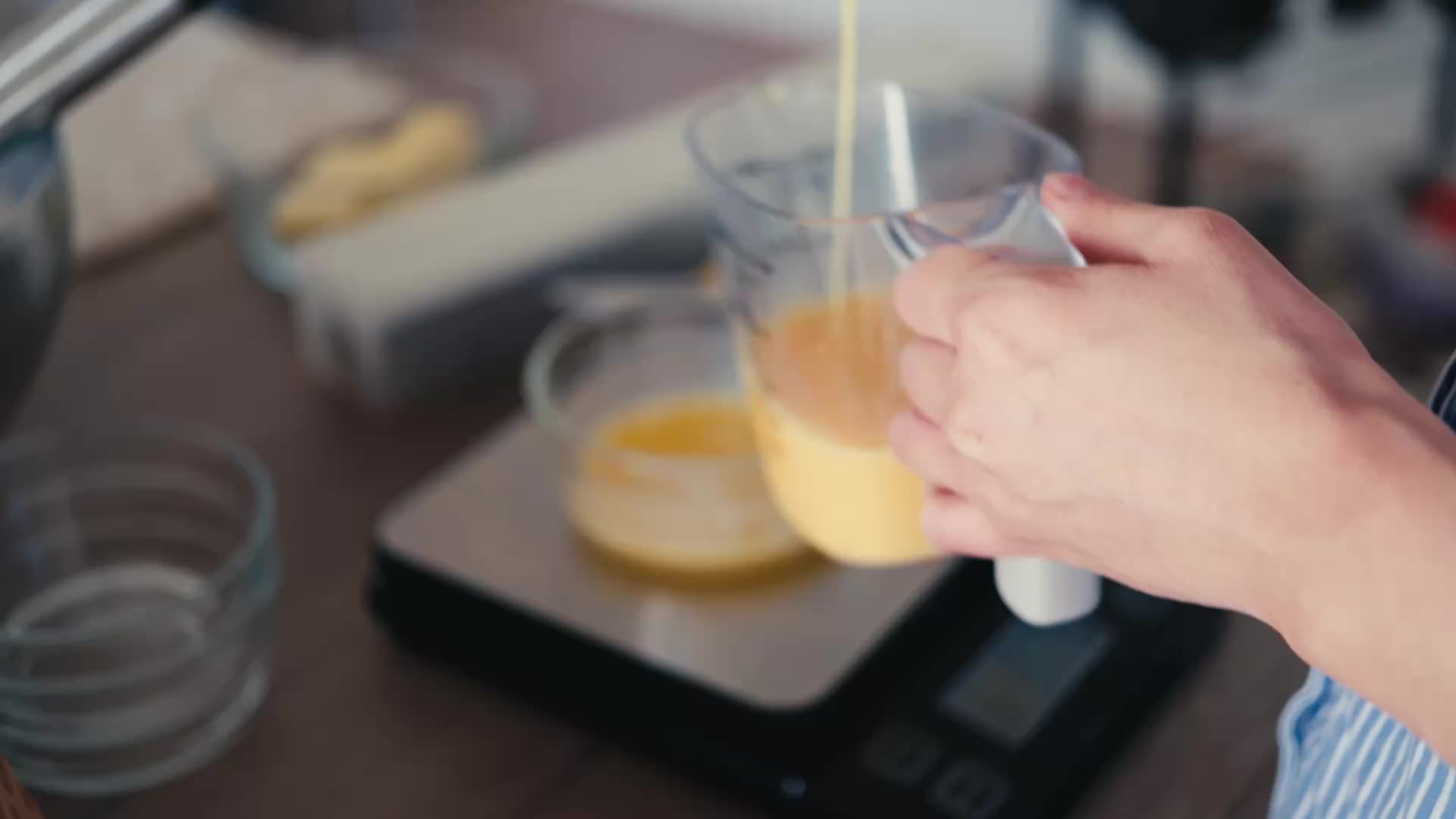 Huevo batido que se vierte en una jarra sobre una báscula de cocina.