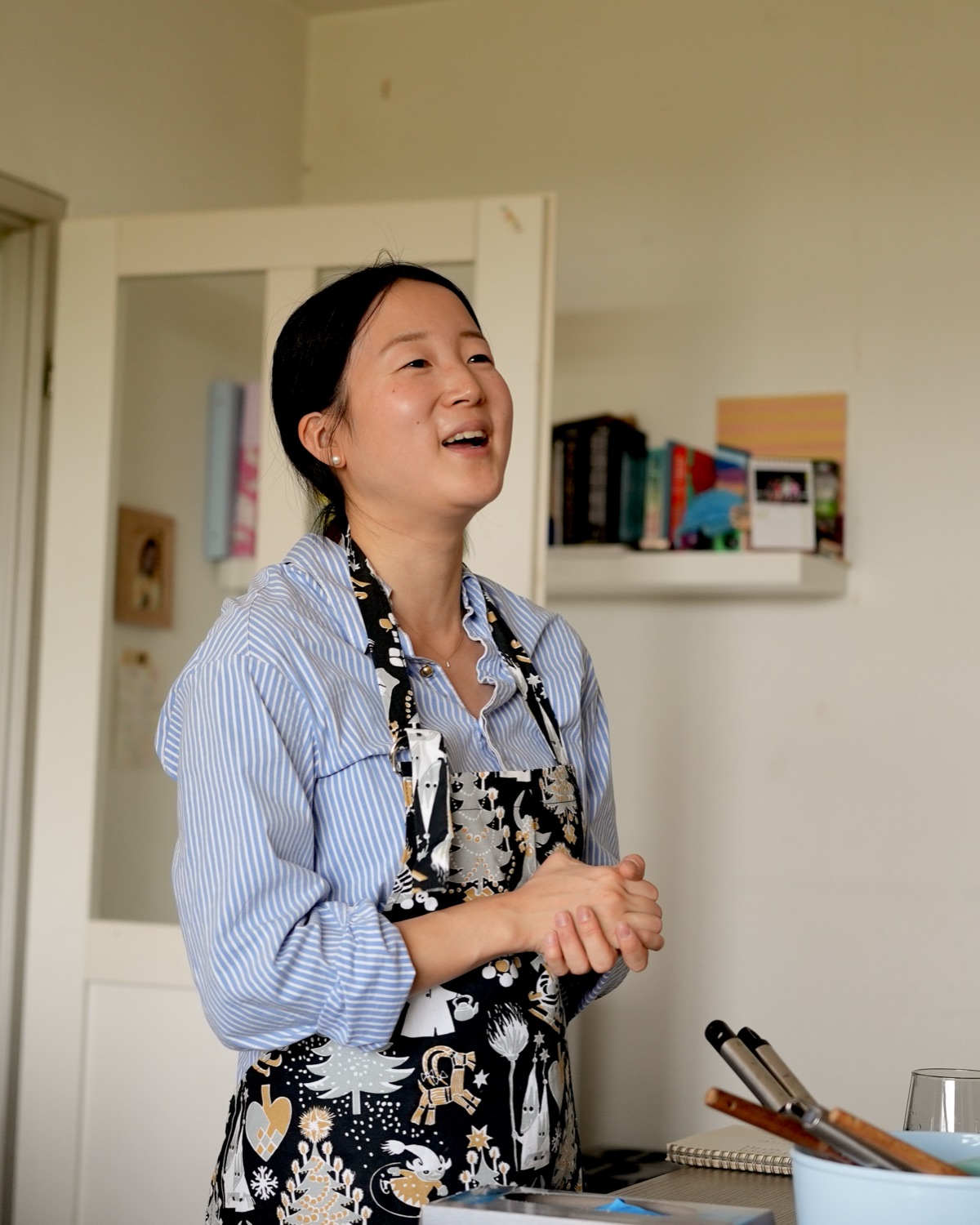 Risa Hasegawa, de Ja!pan Bakery, sonriendo en su cocina con las manos juntas.
